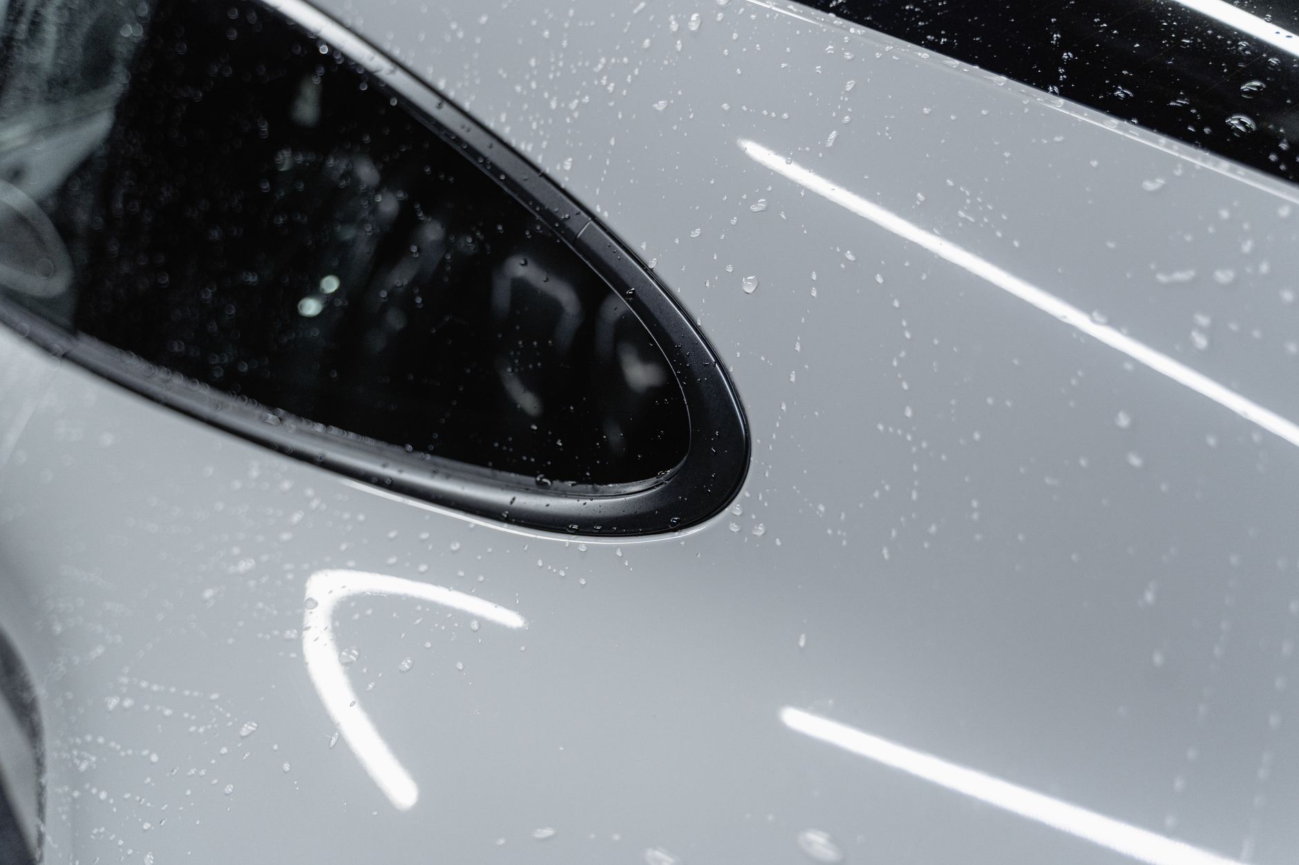 Glossy freshly washed car exterior, water beading on paint