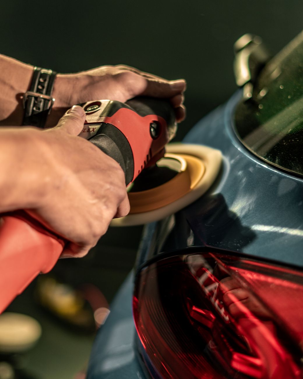 Technician buffing and polishing car paint for correction
